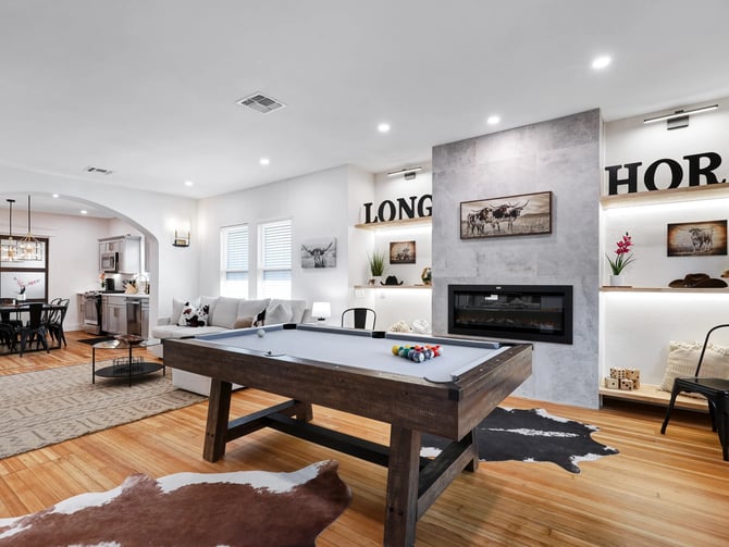 Spacious vacation home living room with pool table and fireplace
