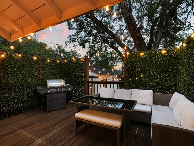 Covered deck with string lights and outdoor seating at dusk